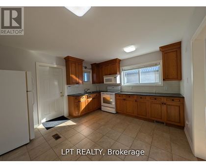 A kitchen with wooden cabinets and a white refrigerator.