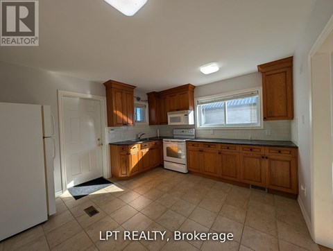 A kitchen with wooden cabinets and a white refrigerator.