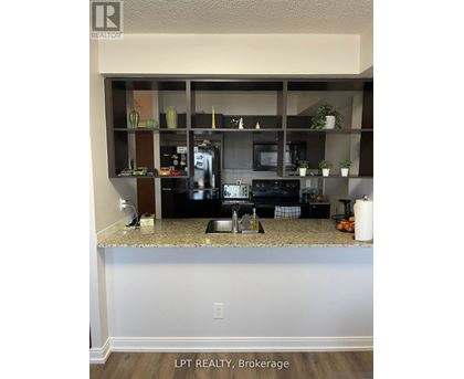 A kitchen with granite countertops and a microwave.