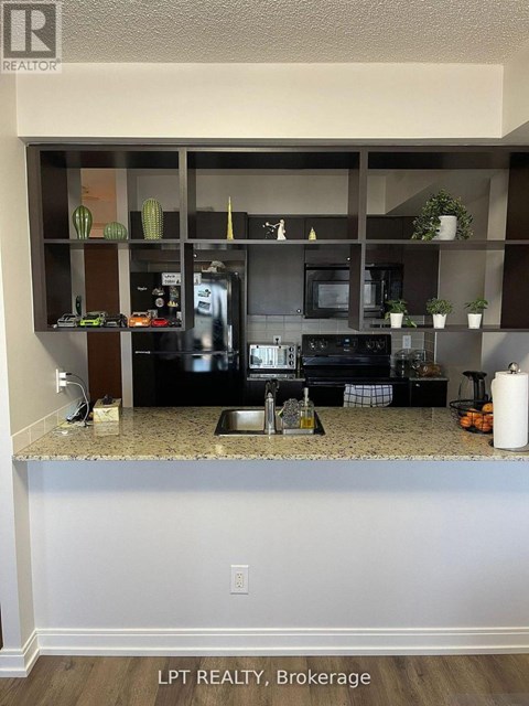 A kitchen with granite countertops and a microwave.