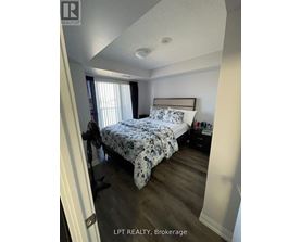 A bedroom with a bed, nightstand, and window.