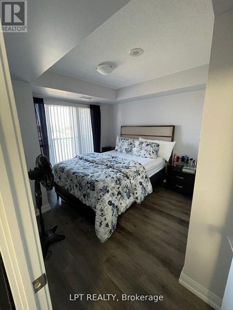A bedroom with a bed, nightstand, and window.