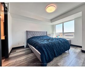 A bedroom with a bed, a window, and a wooden floor.
