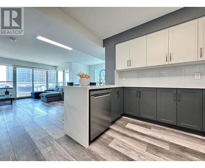 A modern kitchen with a large island and stainless steel appliances.