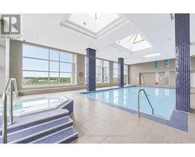 A large indoor swimming pool with a hot tub and a skylight.