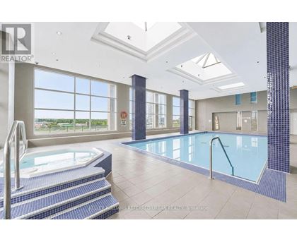A large indoor swimming pool with a hot tub and a skylight.