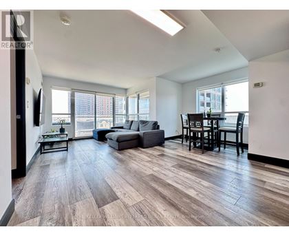 A spacious living room with a grey sofa and a wooden floor.
