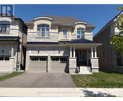 A large house with a stone wall and a black garage door.
