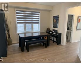A black piano is in a room with a table and bench.