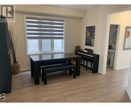A black piano is in a room with a table and bench.