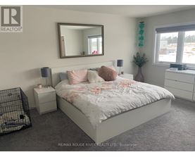 A bedroom with a large bed, a mirror, and a nightstand.