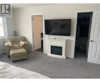 A living room with a couch, chair, and television.