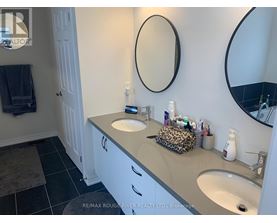 A bathroom with a white vanity and two sinks.