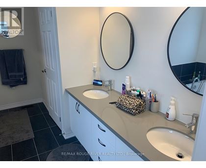 A bathroom with a white vanity and two sinks.