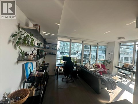 A living room with a couch, a chair, a table, and a large window.