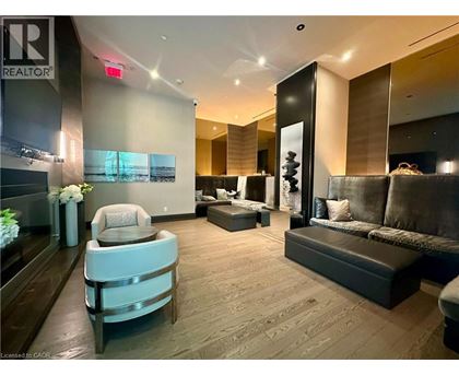 A well-lit, modern living room with a grey sofa and a wooden floor.