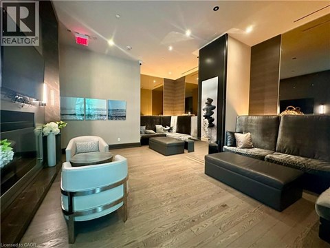 A well-lit, modern living room with a grey sofa and a wooden floor.