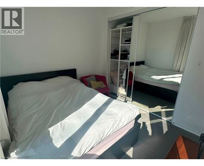 A bedroom with a bed, a mirror, and a wardrobe.