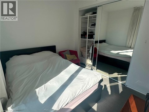A bedroom with a bed, a mirror, and a wardrobe.