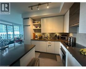 A modern kitchen with white cabinets and black countertops.