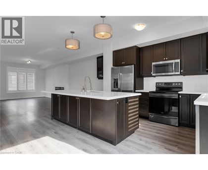 A modern kitchen with dark brown cabinets and stainless steel appliances.