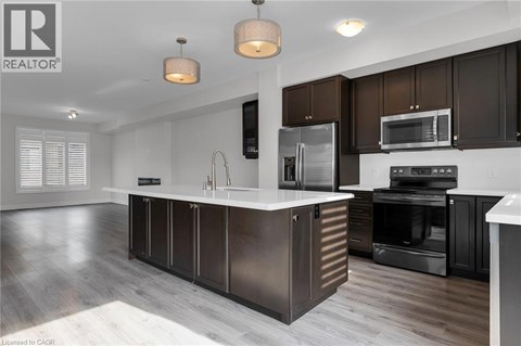 A modern kitchen with dark brown cabinets and stainless steel appliances.
