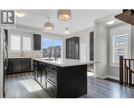 A modern kitchen with black cabinets and a white countertop.