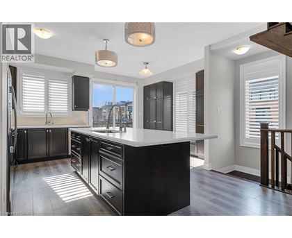 A modern kitchen with black cabinets and a white countertop.