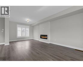 A spacious living room with a fireplace and wood flooring.