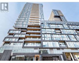 A tall building with many windows and balconies, with a sign that reads "REALTOR®".
