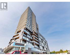 A tall building with a glass facade and a logo of a realtor on the bottom left.