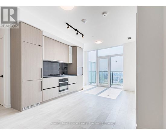 A modern kitchen with wooden cabinets and a large window.