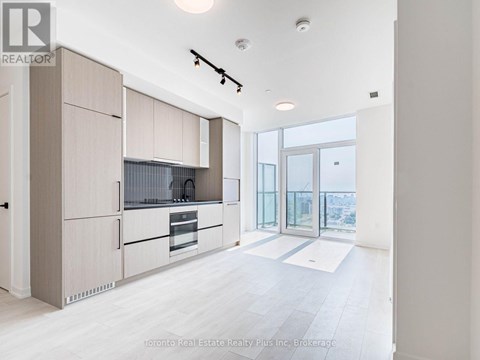 A modern kitchen with wooden cabinets and a large window.