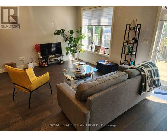 A living room with a grey couch, a yellow chair, and a glass coffee table.