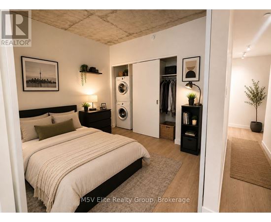 A bedroom with a bed, a washing machine, and a potted plant.