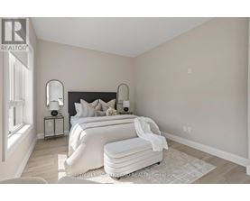 A bedroom with a large bed and a nightstand with a lamp.