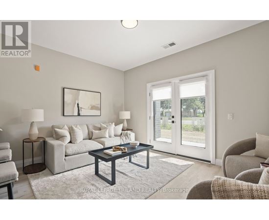 A living room with a grey couch, a coffee table, and a painting on the wall.