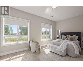 A bedroom with a large bed and two windows.