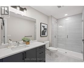 A white bathroom with a toilet, sink, and mirror.