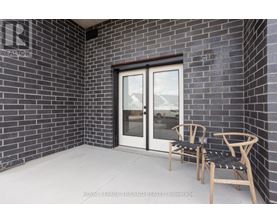 A patio with a chair and table outside a house.
