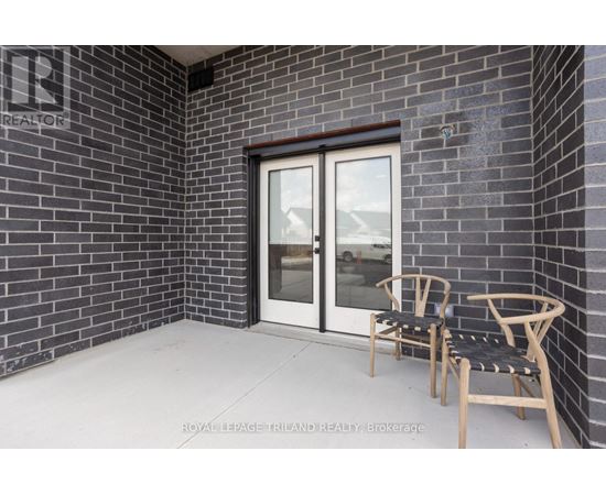 A patio with a chair and table outside a house.