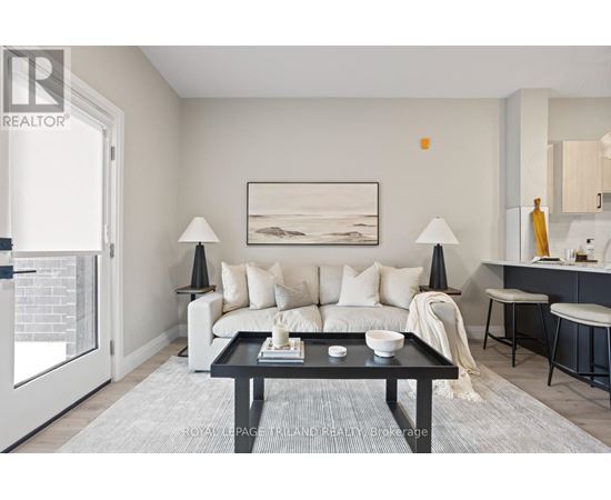 A modern living room with a white sofa, a black coffee table, and a painting on the wall.