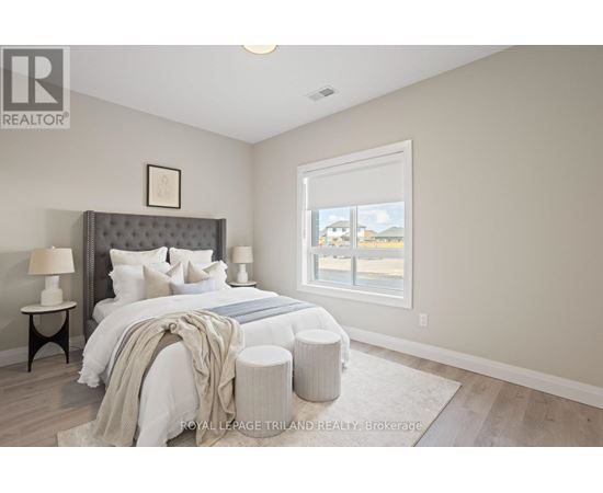 A bedroom with a large bed and a window overlooking a street.