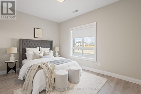 A bedroom with a large bed and a window overlooking a street.