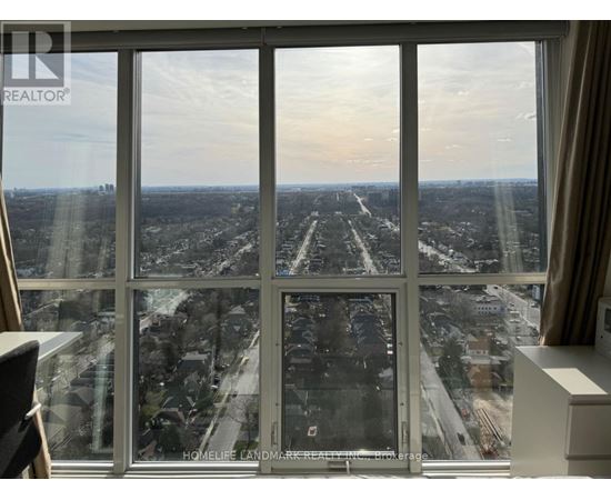 A view from a high-rise window looking out at a cityscape.