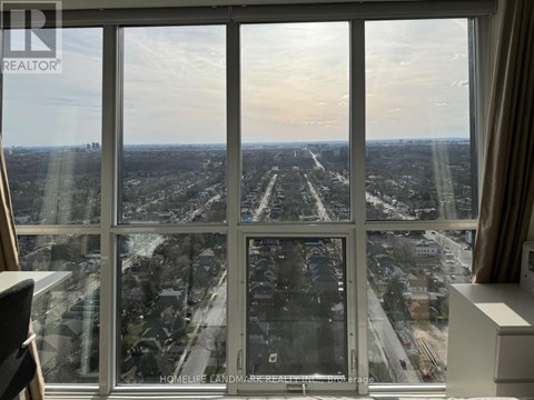 A view from a high-rise window looking out at a cityscape.