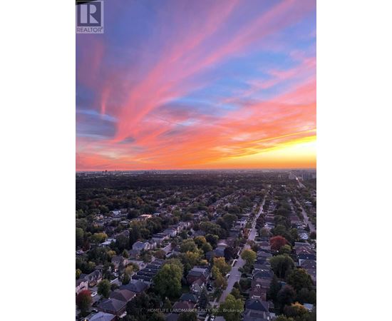 A sunset view of a residential neighborhood with houses and trees.