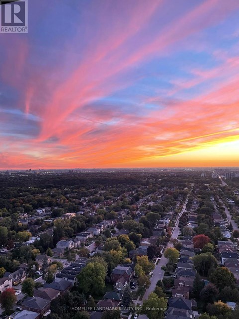 A sunset view of a residential neighborhood with houses and trees.