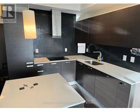 A modern kitchen with dark brown cabinets and a white countertop.
