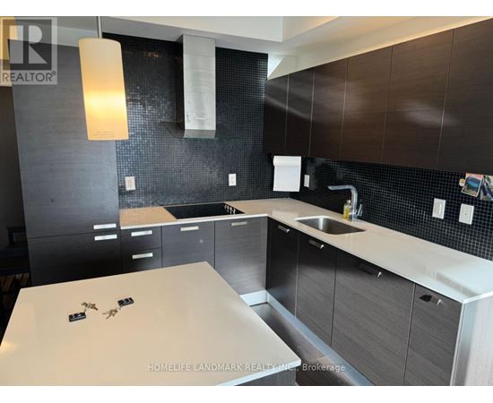 A modern kitchen with dark brown cabinets and a white countertop.